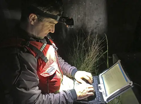 un homme travaille sur un ordinateur portable la nuit