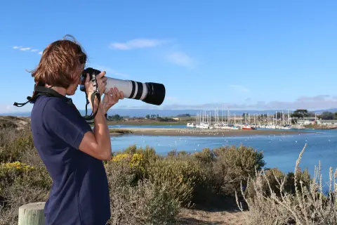 Une femme regardant l'eau à travers une caméra