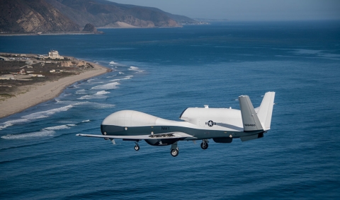 Un avion blanc survole l'océan