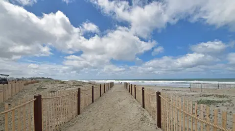 Deux clôtures cordées de chaque côté d'un chemin de plage