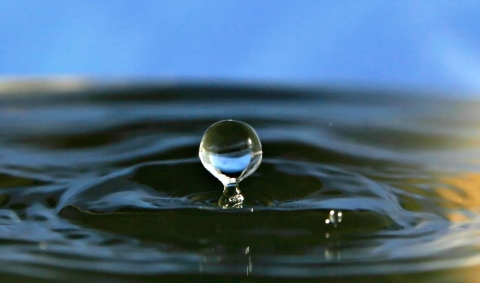   Une goutte d'eau tombant dans un plan d'eau et provoquant des ondulations