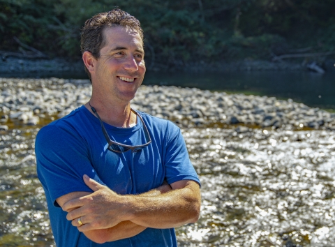 un homme debout à côté d'une rivière