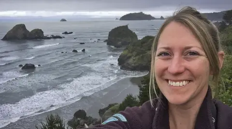 une femme prenant un selfie à l'océan.