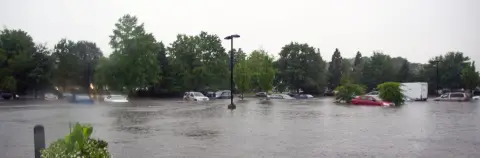 Parking inondé avec des voitures submergées dans l'eau. 