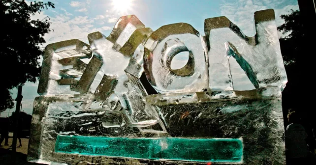 Sculpture de glace en forme de logo Exxon contre un ciel bleu vif.