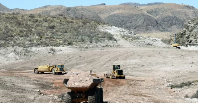 Des camions de construction transportent et poussent de la terre au projet minier Shafter.