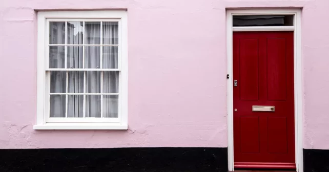 Une maison rose sans personne dehors.