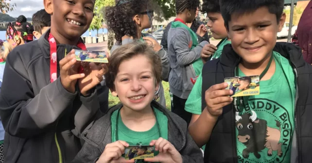 Trois élèves de quatrième année avec leurs laissez-passer Every Kid in a Park.