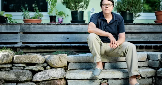 Charles C. Mann est assis sur le porche rocheux de sa maison à Amherst, dans le Massachusetts.