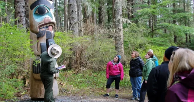 Ranger montrant aux visiteurs du parc un totem au parc historique national de Sitka.