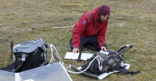 Un scientifique mesure une chambre à toit ouvert sur le terrain.
