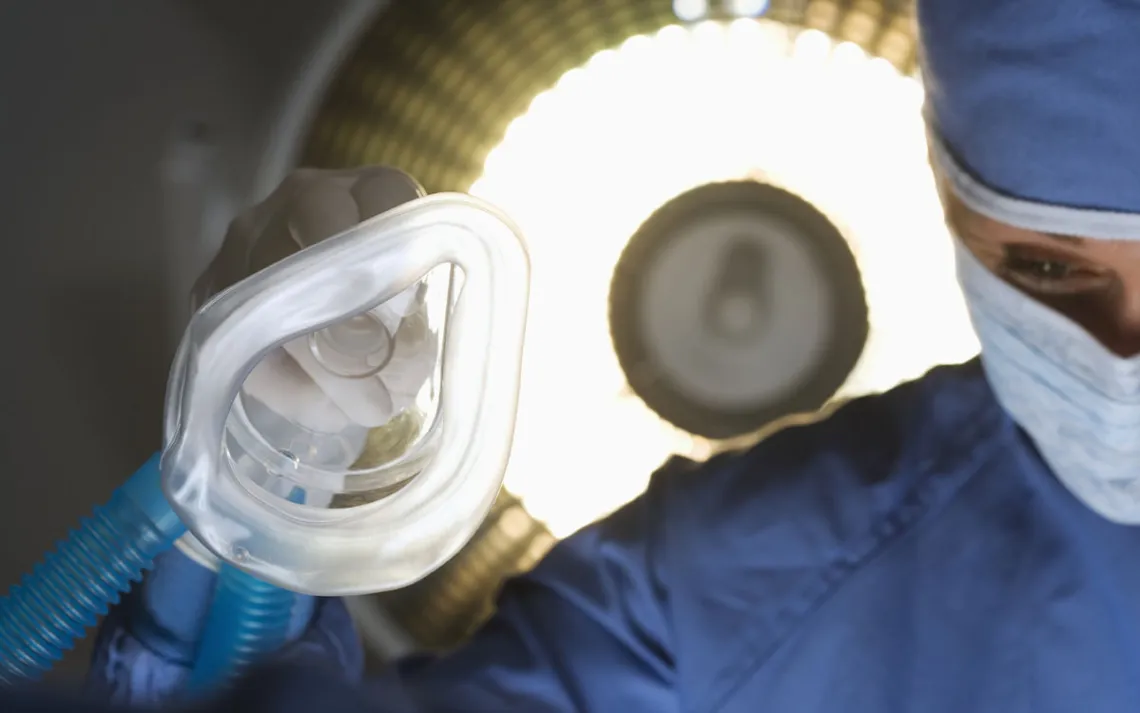 Un médecin tient un masque de nébuliseur dans une salle d'opération