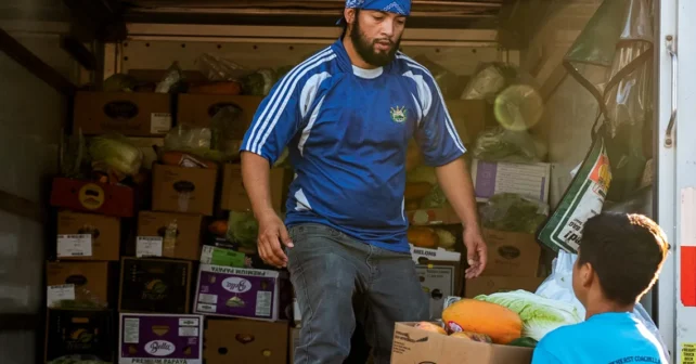 Les bénévoles remplissent un U-Haul de cartons de produits frais à livrer aux parcs à roulottes locaux.