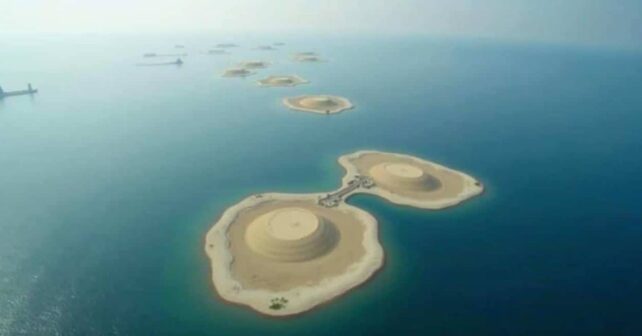 Vista aérea de varias islas artificiales construidas con arena en mar abierto, con formas circulares y una pasarela que conecta dos de ellas