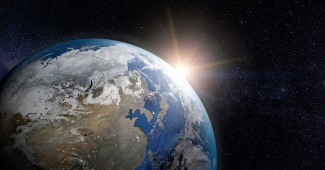 La Tierra vista desde el espacio con el Sol iluminando la órbita donde Japón probará energía solar espacial.