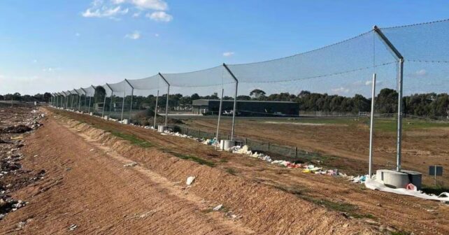 Vallas de contención en un vertedero de Australia para evitar que la basura llegue a campos y fauna.