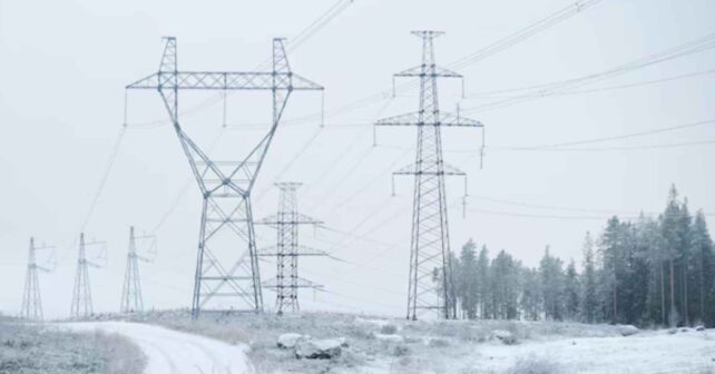 Torres de alta tensión en Finlandia bajo nieve intensa durante una crisis energética invernal.