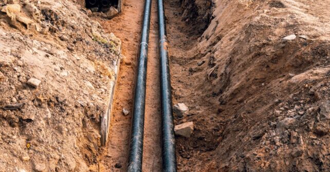 Tuberías de riego por goteo subterráneo enterradas a 30 cm para ahorrar agua en cultivo agrícola.