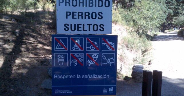 Cartel de prohibido llevar perros sueltos en un espacio natural protegido de España.