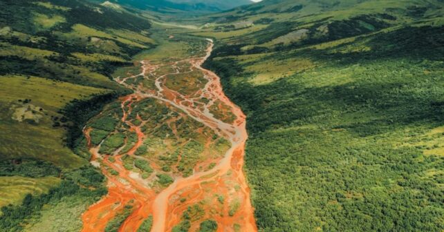 Río teñido de color naranja por la liberación de metales tóxicos tras el deshielo del permafrost en Canadá.