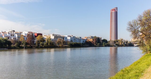 Orilla del río Guadalquivir en Sevilla con la Torre Sevilla al fondo