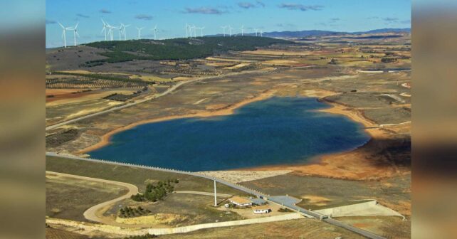 Vista aérea del embalse de Campos del Paraíso, que regula el agua de la Llanura Manchega, con la presa y sus edificios en primer plano